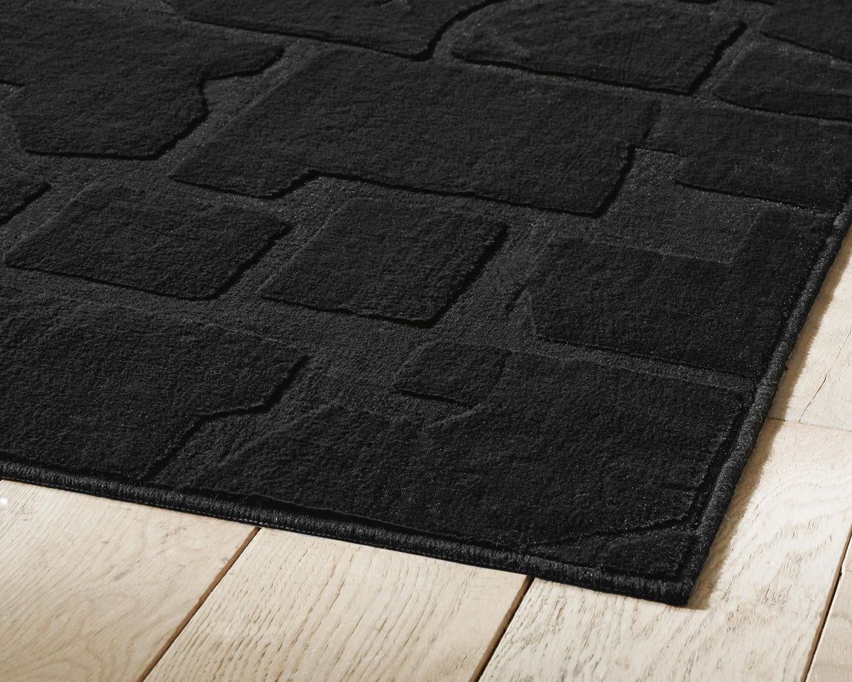 Gibbswell Washable 5' x 7' Area Rug in Black, detail view