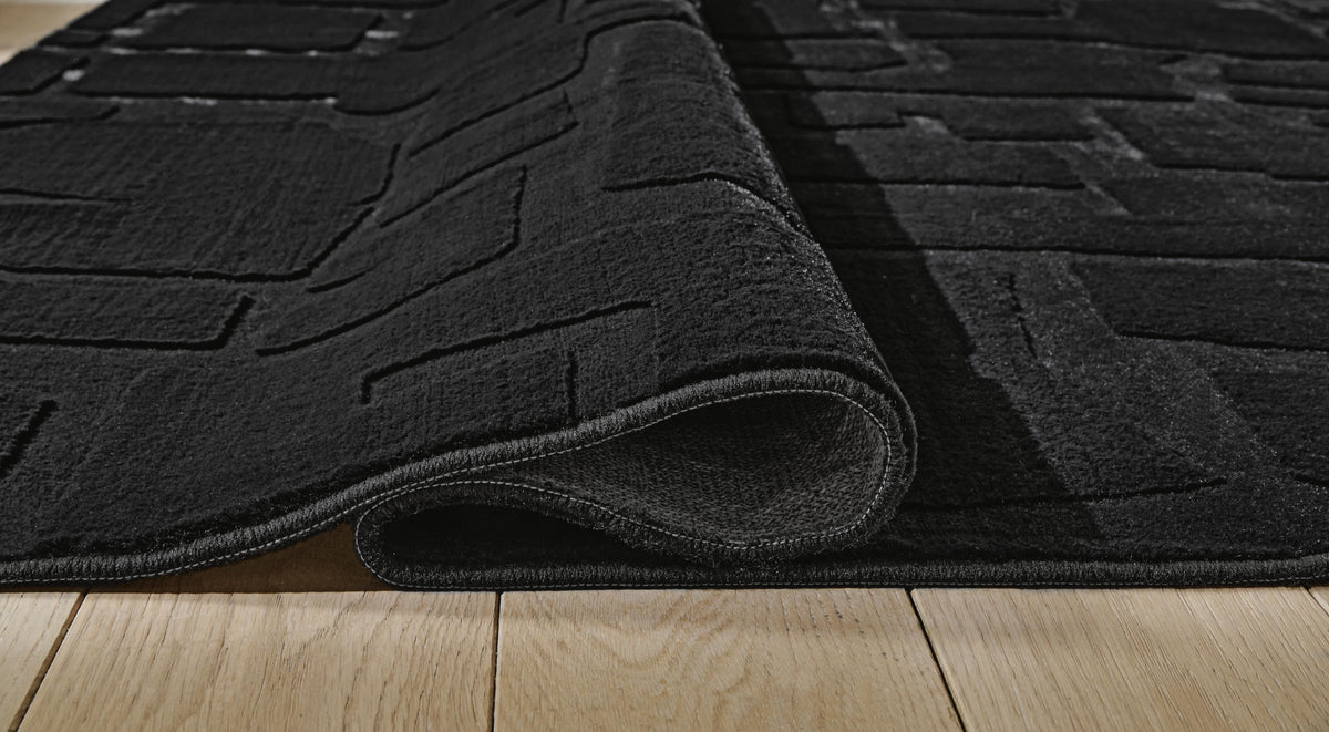 Gibbswell Washable 5' x 7' Area Rug in Black, detail view